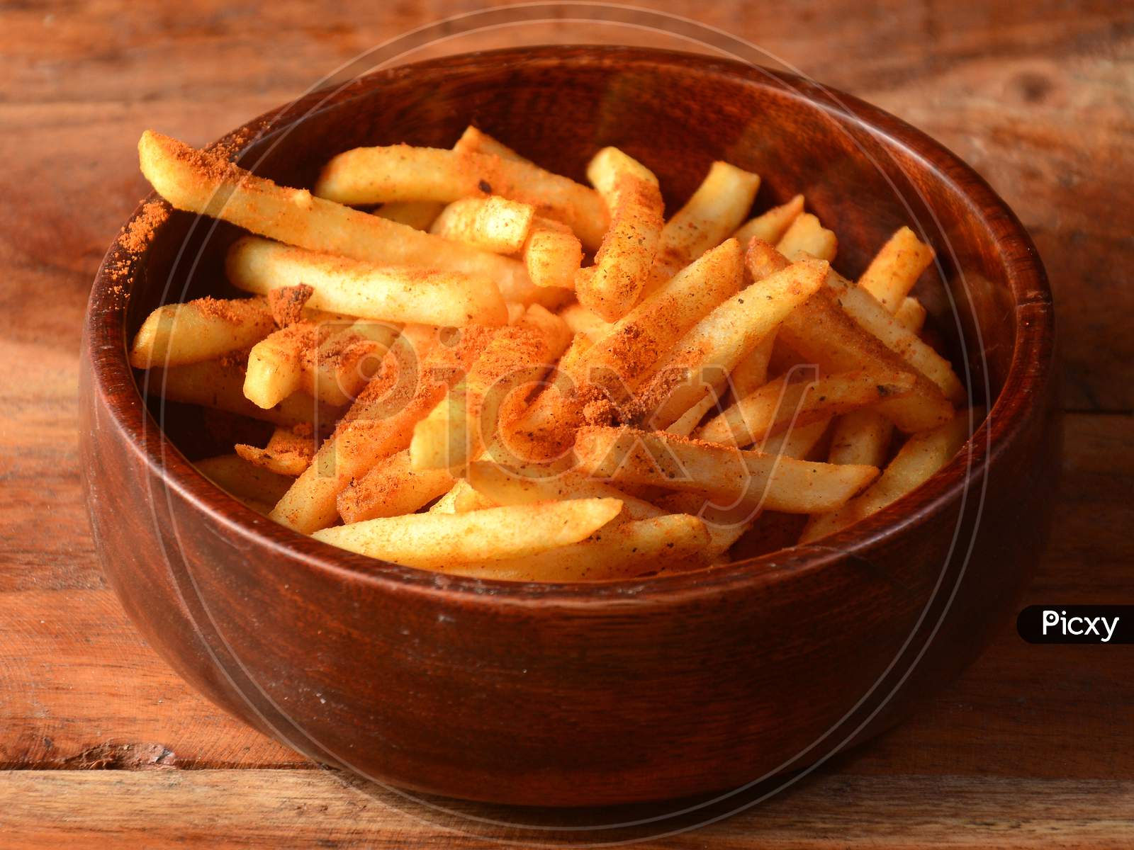Tasty Spicy Peri Peri French Fries Served In A Wooden Bowl Over A Rustic Wooden Background, Selective Focus