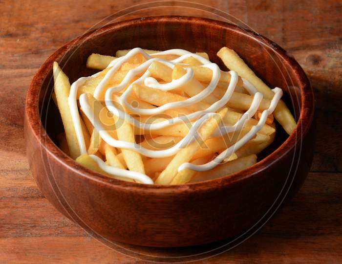 French Fries Topped With Cheese, Served In A Wooden Bowl Over A Rustic Wooden Background, Selective Focus