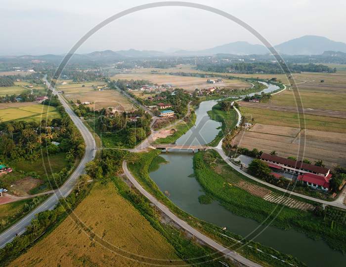 Aerial View Rural Area Of Malays Village With Background Paddy Field