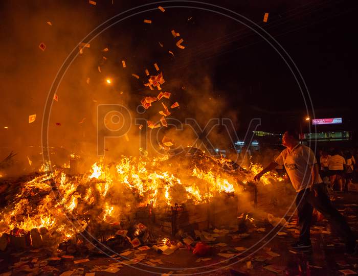 People Throw Offering Into The Flames During Hungry Ghost Festival