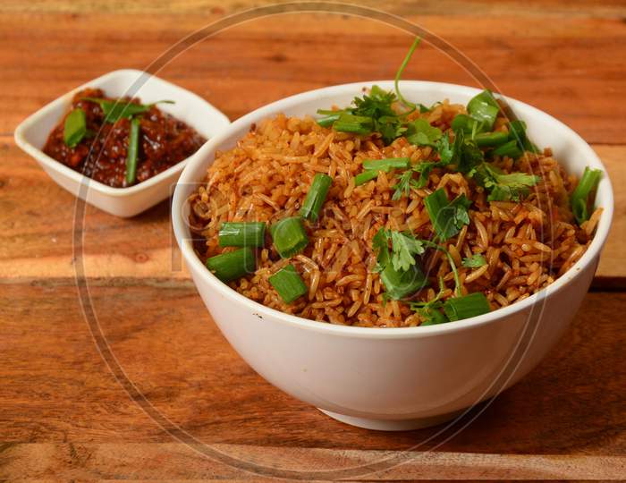 Tasty Veg Schezwan Fried Rice Served In Bowl Over A Rustic Wooden Background, Indian Cuisine, Selective Focus