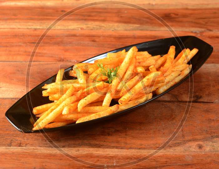 Tasty Spicy Peri Peri French Fries Served In A Bowl Over A Rustic Wooden Background, Selective Focus