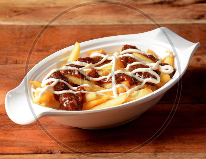 French Fries Topped With Salsa Cheese, Served In A Bowl Over A Rustic Wooden Background, Selective Focus