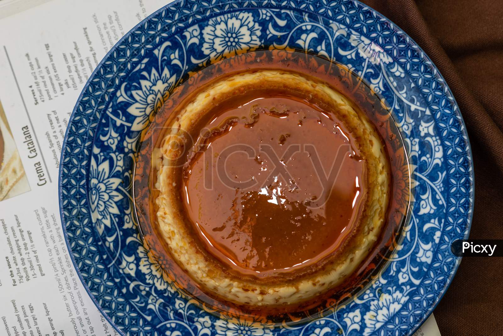 Image of Caramel custard/pudding on a china plate with nice background. Image for Restaurant menu and food magazines