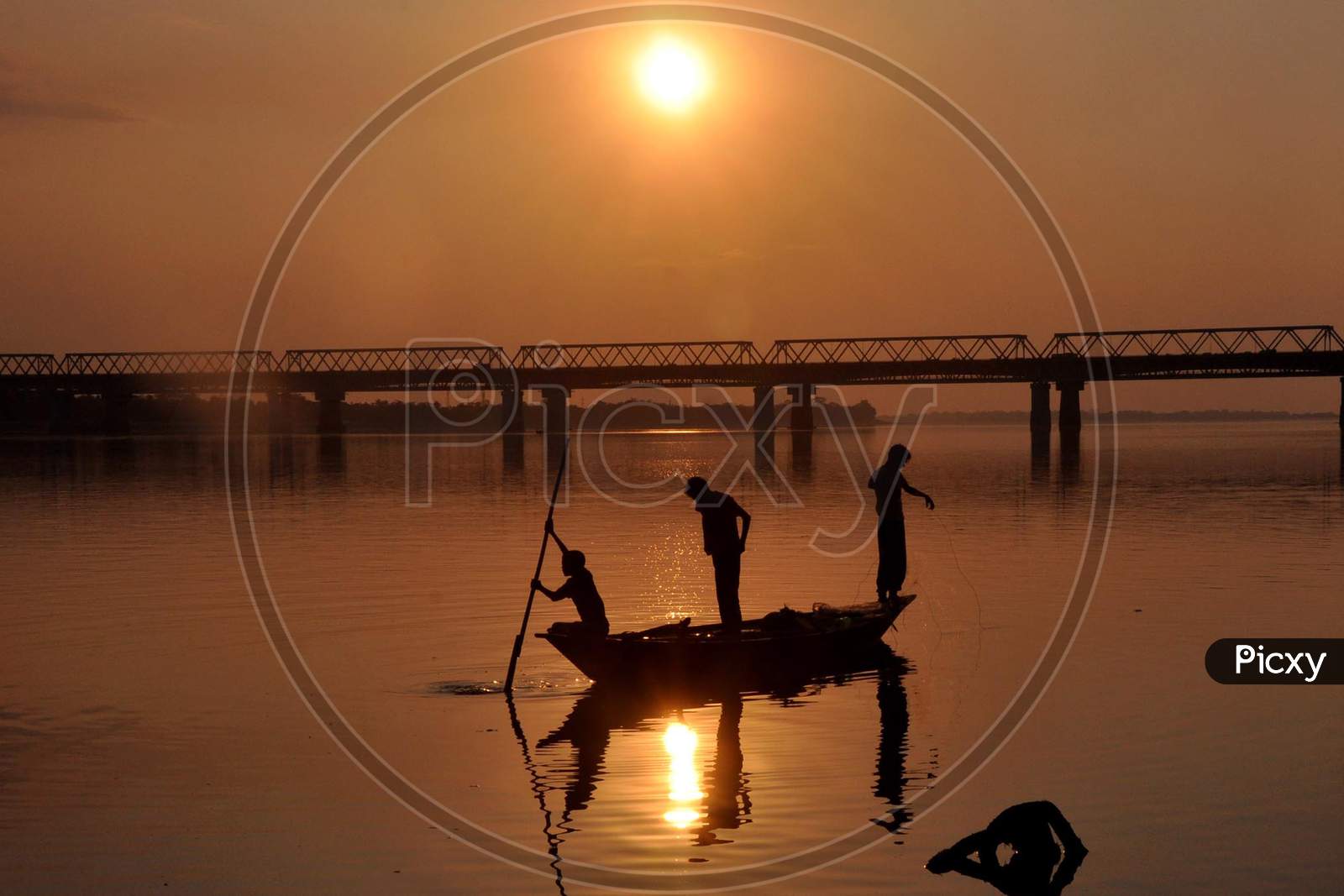Indian fishermen lay their fishing nets in Brahmaputra River at sunset in Guwahati ,india on December 3,2020.
