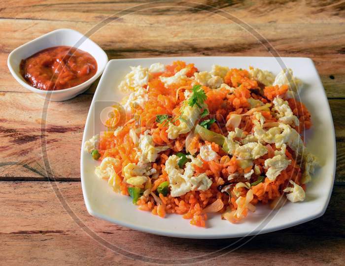 Tasty Schezwan Egg Fried Rice With Tomato Sauce Served In White Plate Over A Rustic Wooden Background, Indian Cuisine, Selective Focus