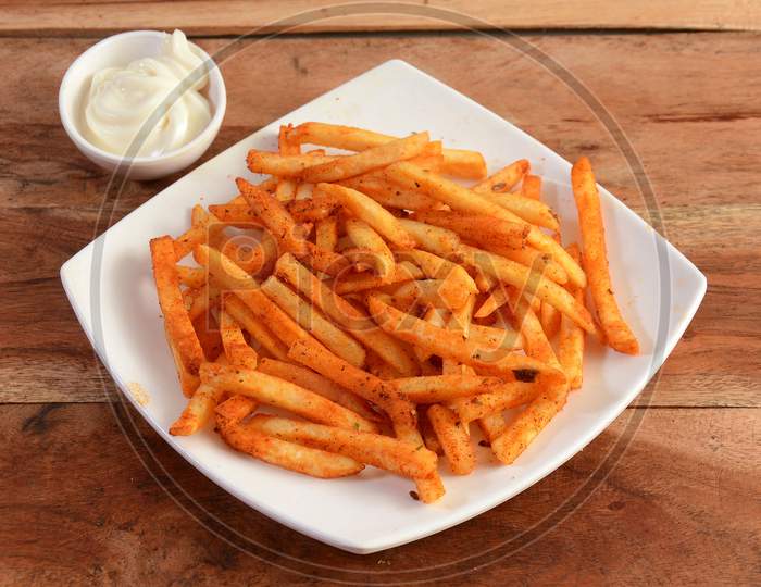 Tasty Spicy Peri Peri French Fries With Mayonnaise Served In A Plate Over A Rustic Wooden Background, Selective Focus