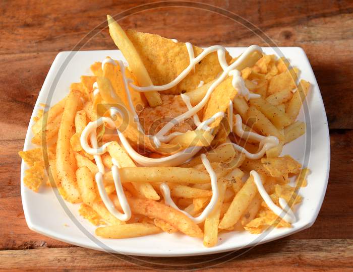 French Fries Topped With Cheese, Served In A Plate Over A Rustic Wooden Background, Selective Focus