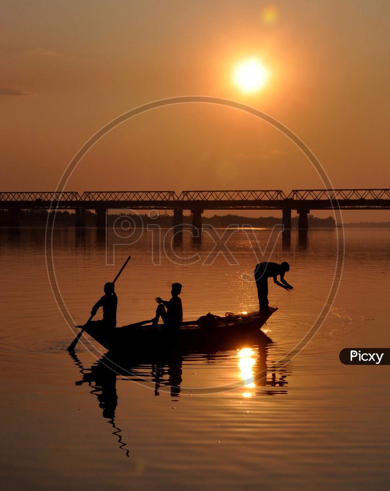 Indian fishermen lay their fishing nets in Brahmaputra River at sunset in Guwahati ,india on December 3,2020.