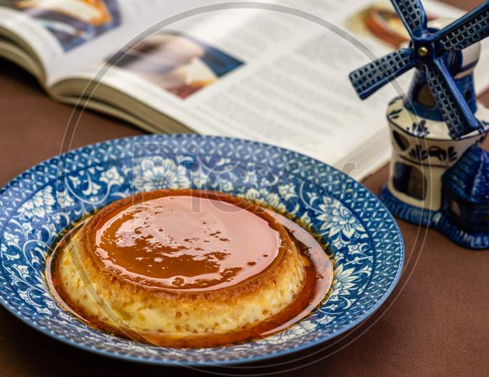 Image of Caramel custard/pudding on a china plate with nice background. Image for Restaurant menu and food magazines