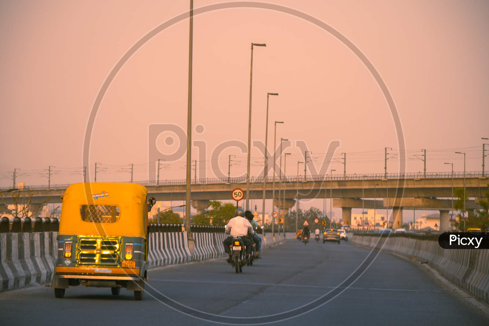 Traffic On Empty Street In Jaipur At Dusk With Golden Light And Autorickshaw Bikes On The Roads