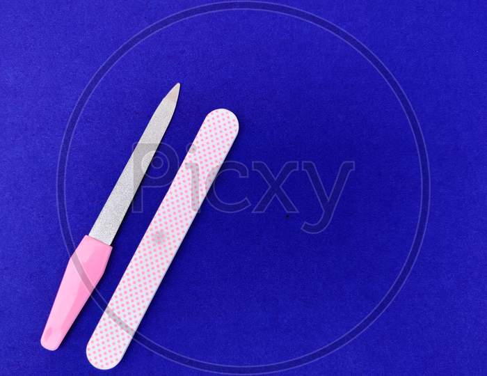 Two Manicure Tools Isolated On Blue Background. Copy Space