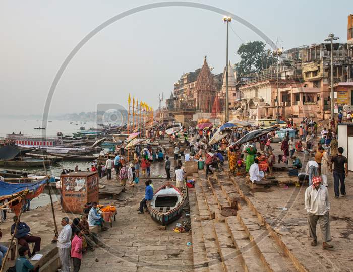 People Wash And Bath In Ganges River At One Of The Many Ghats Of Varanasi Old City