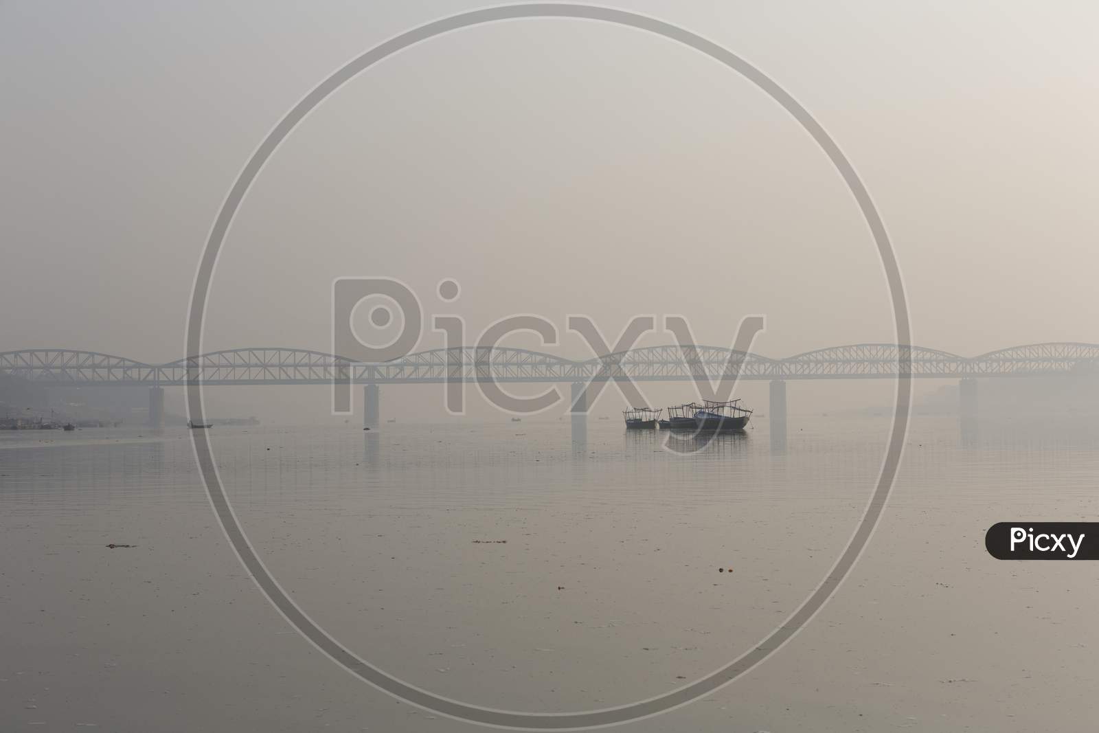 View Of A Ghat (Riverfront Steps) Of Sacred River Ganges In Varanasi, India. Malviya Bridge In The Background