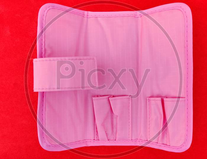 Pink Color Manicure Tools Pouch Isolated On Red Background.