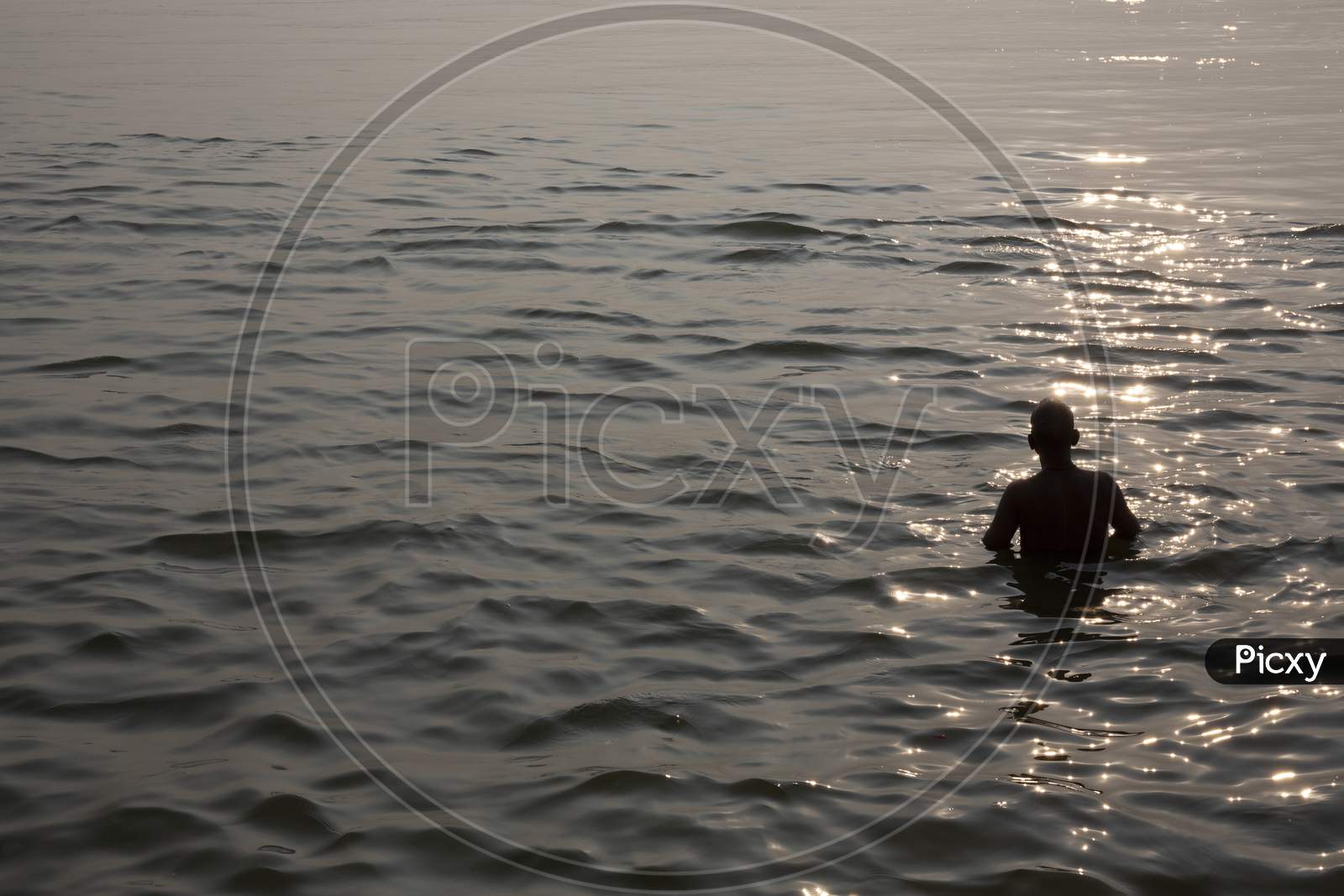 Silhouette Of A Man Taking Bath In Ganges River During Sunset