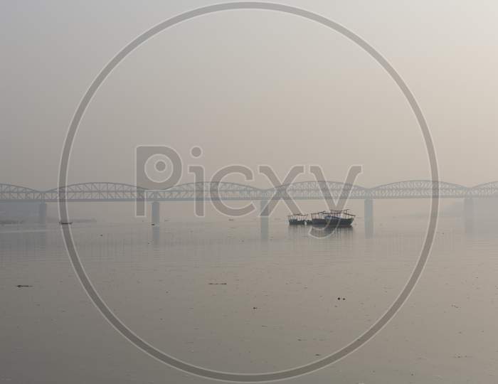 View Of A Ghat (Riverfront Steps) Of Sacred River Ganges In Varanasi, India. Malviya Bridge In The Background