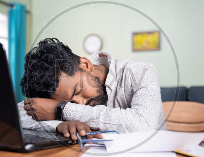 Young Man Got Tired Of Working And Slept On Desk - Exhausted Millennial Fall Asleep After After Reading On Laptop - Concept Of Napping At Workplace And Over Work Hours