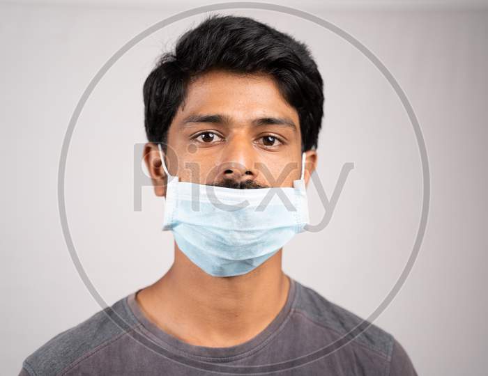 Young Man Wearing Medical Mask Below Nose - Concept Showing Of Improper Way Of Using Face Masks During Coronavirus Or Covid-19 Crisis.