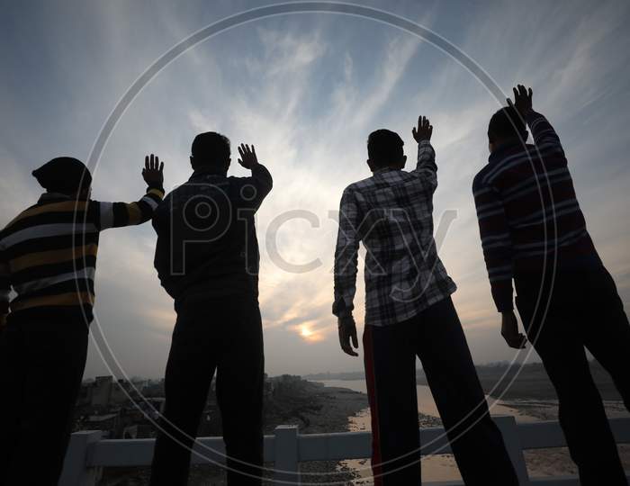Youngster waving Last sunset of 2020 on the eve of New year in Jammu  on 31 Dec,2020.