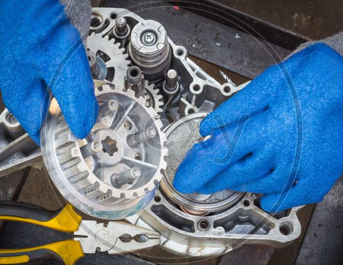 A Clutch bell is being assembled on to a Motorcycle engine case during an Engine Overhauling procedure at a two wheeler Garage in Mysuru,India.