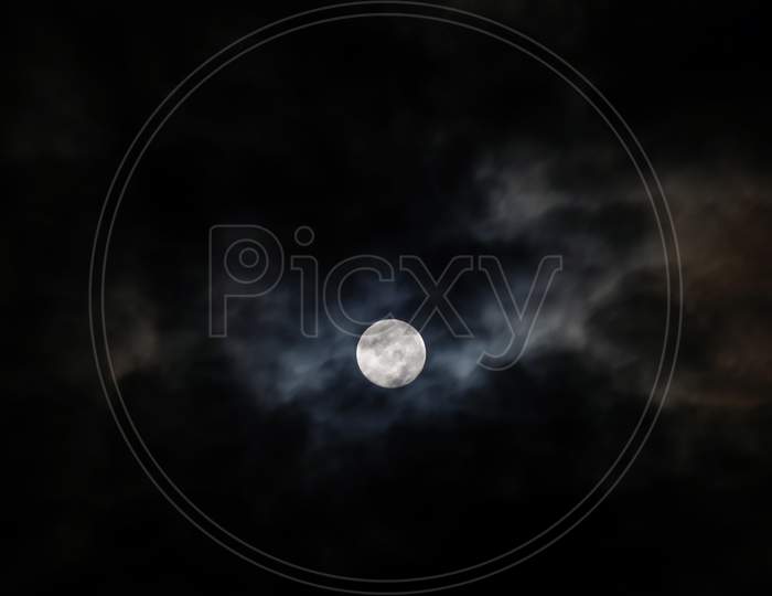 The Moon Behind The Clouds. The Moon In A Partially Clouded Colorful Sky.