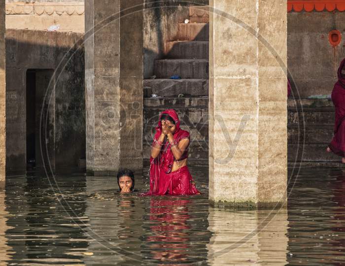 Unidentified Hindu Women Pilgrims Take Bath In The Holy River Ganges At The Ghats Of Varanasi, Uttar Pradesh, India