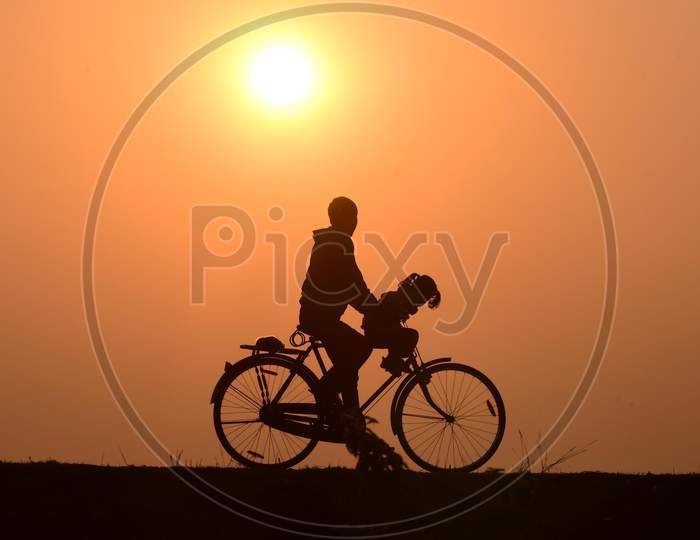 A man rides a bicycle during  the last sunset of the year in  Assam on Dec 31,2020