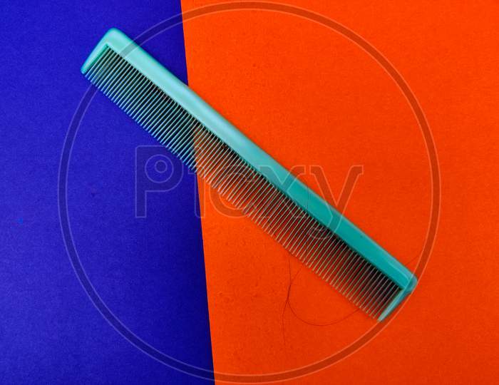 Green Color Used Comb Isolated On Blue And Orange Background