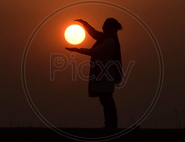 A girl enjoy the last sunset of the year in  Assam on Dec 31,2020