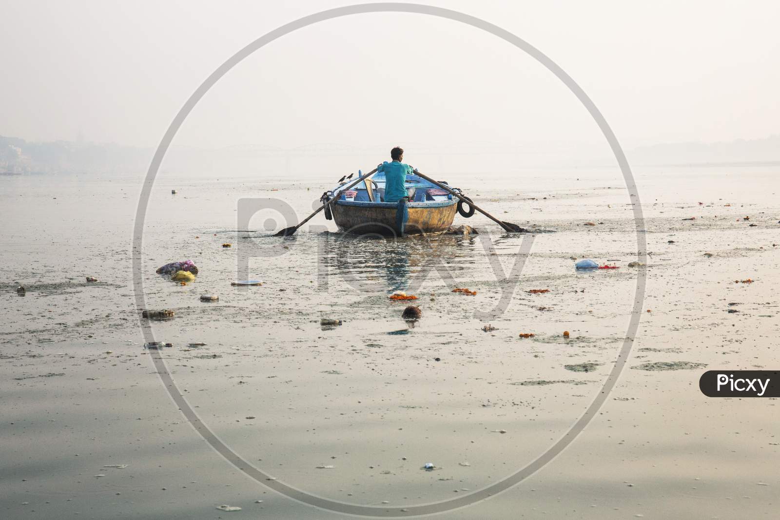 GosMan Rowing A Wooden Boat Crosses The Ganges River Varanasi India