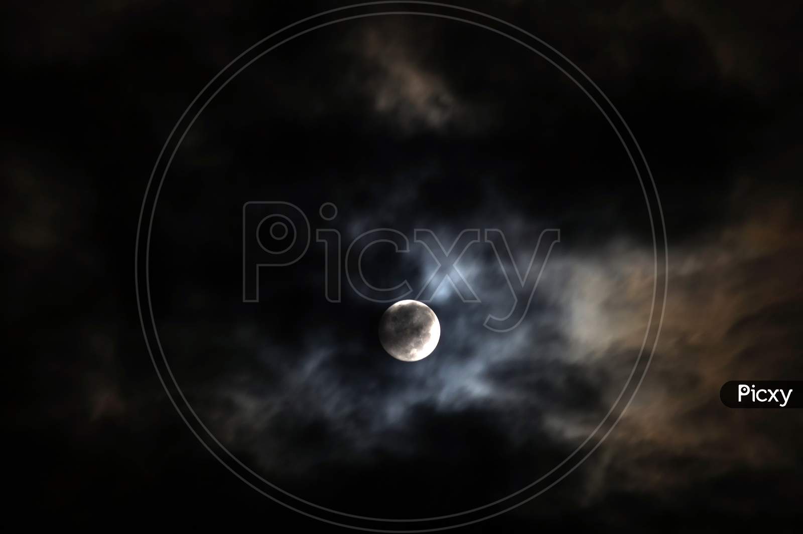 The Moon Behind The Clouds. The Moon In A Partially Clouded Colorful Sky.