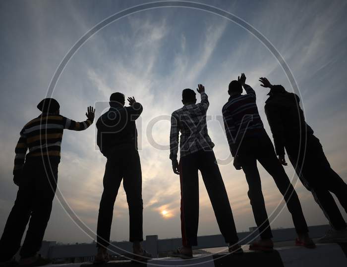 Youngster waving Last sunset of 2020 on the eve of New year in Jammu  on 31 Dec,2020.