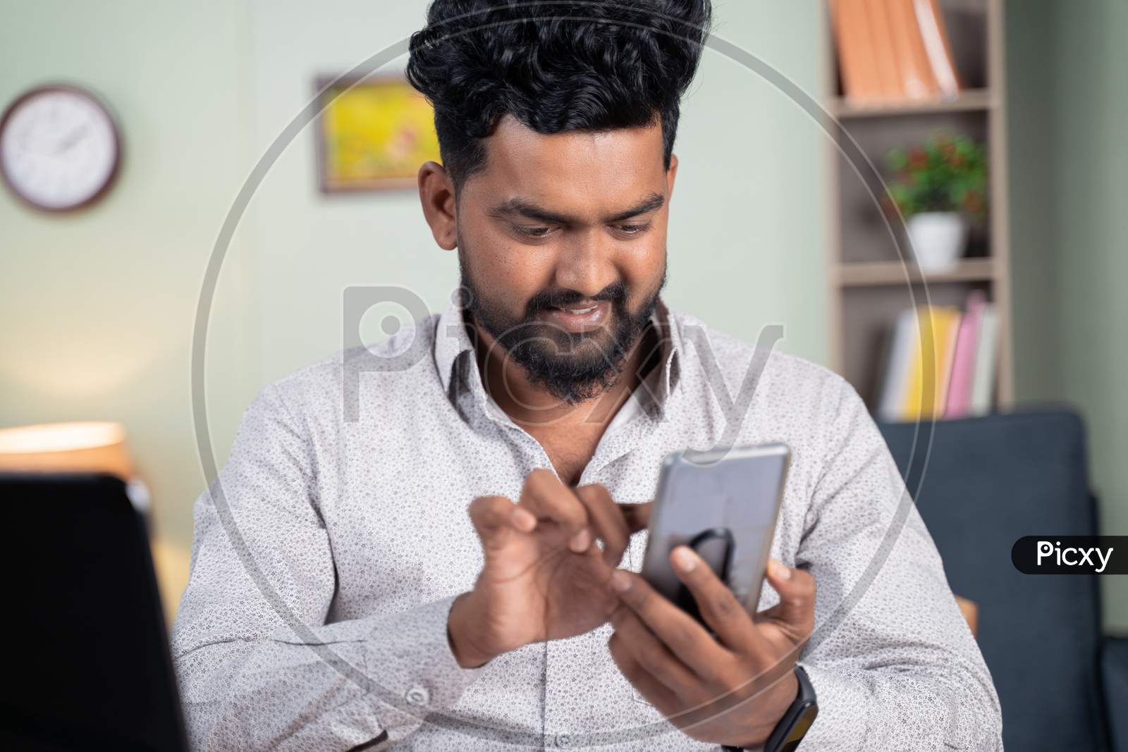 Young Man Smiling By Reading Funny Message Or Sms On Mobile Phone At Office - Concept Of Using Social Media, Internet And Entertainment Lifestyle.