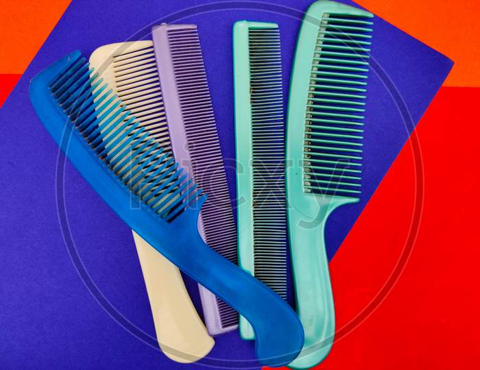 Group Of Used Combs Isolated On Red And Blue Background