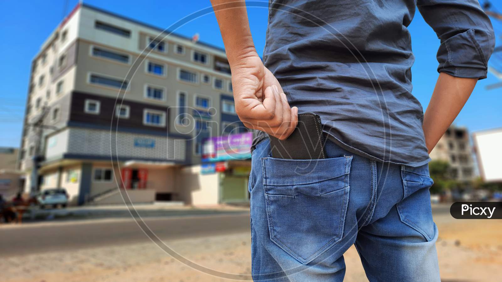 Young Indian Man Pulling Out Wallet From Back Pocket In Market