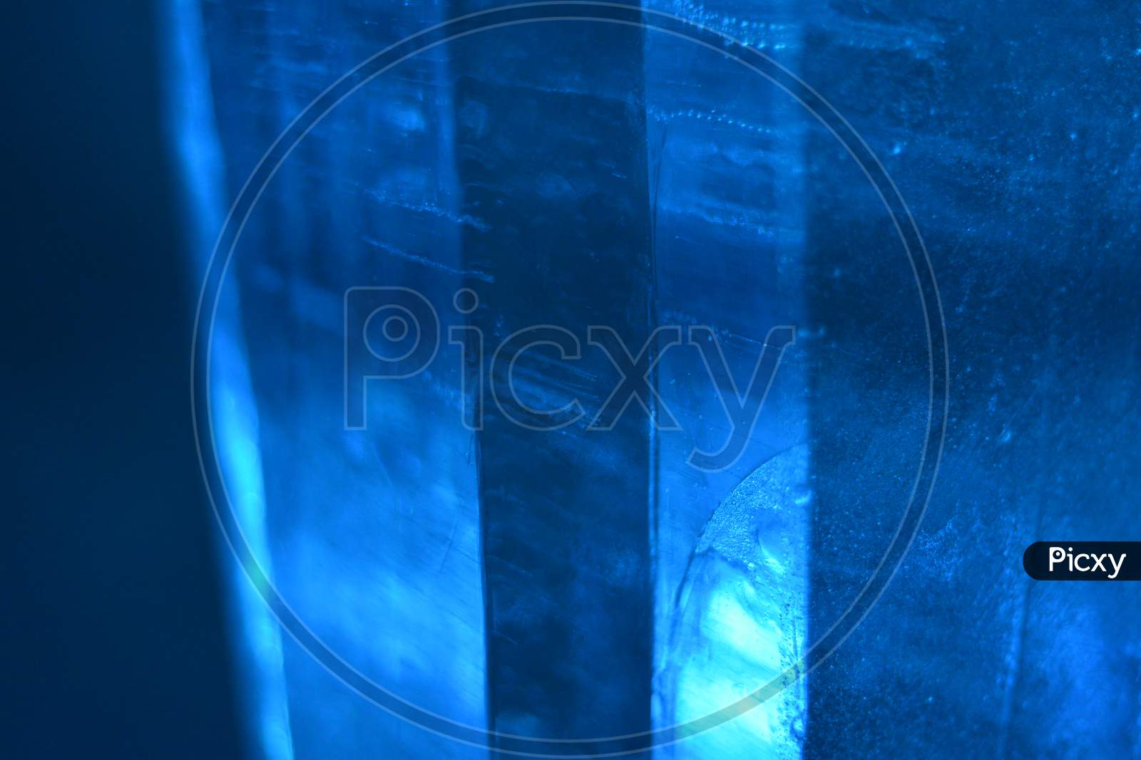 Abstract Photo Of Real Ice In Columns With Blue Light, Forming A Good Landscape Background.
