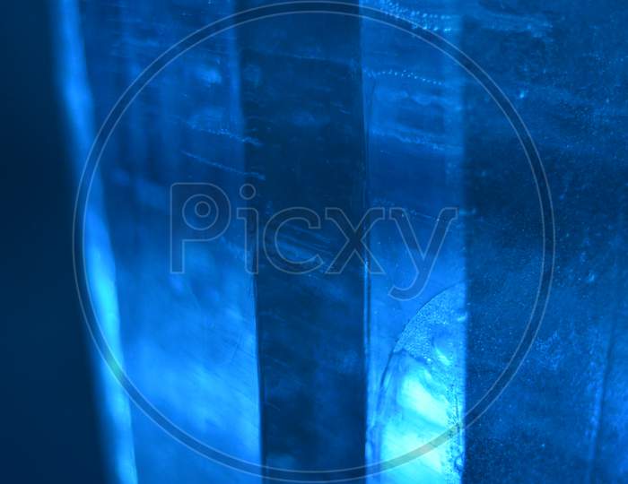 Abstract Photo Of Real Ice In Columns With Blue Light, Forming A Good Landscape Background.
