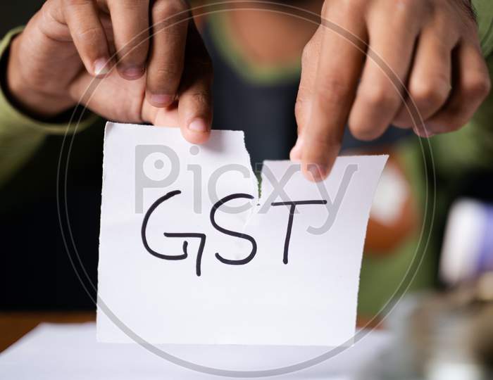 Close Up Of Hands Tearing Of Gst Paper - Concept Against Goods And Service Tax.
