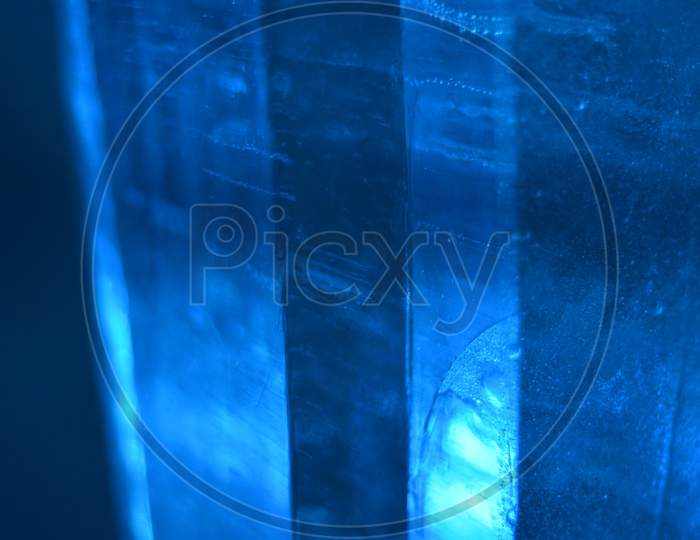 Abstract Photo Of Real Ice In Columns With Blue Light, Forming A Good Landscape Background, Noise Reduced