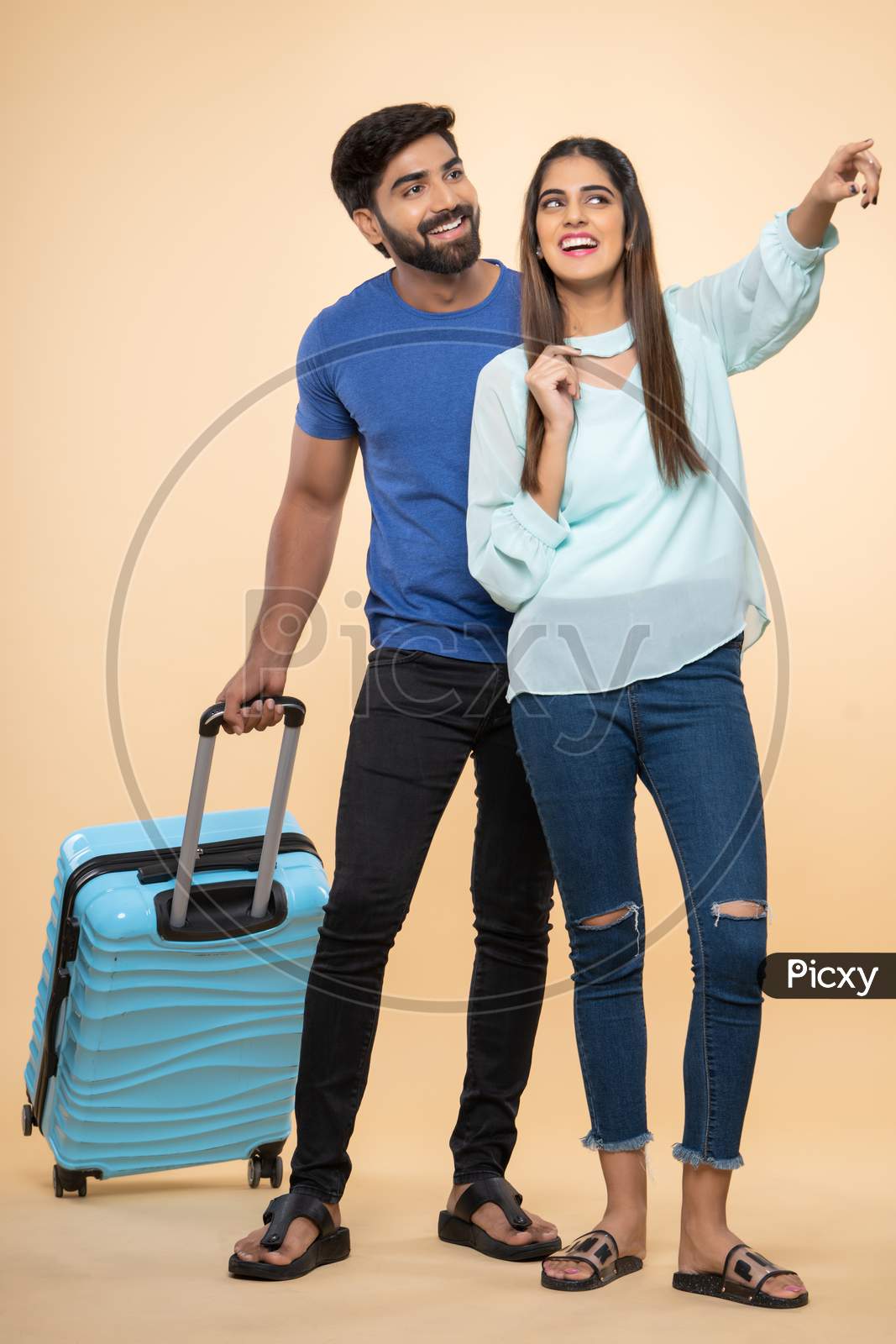 Indian young couple travelers with a trolley bag