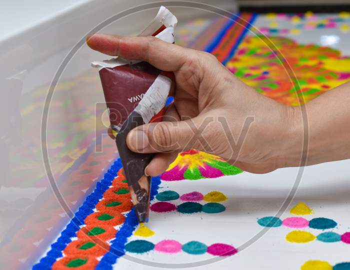 Woman Hand Making Rangoli Designs With Paper Cone Using Rangoli Colors
