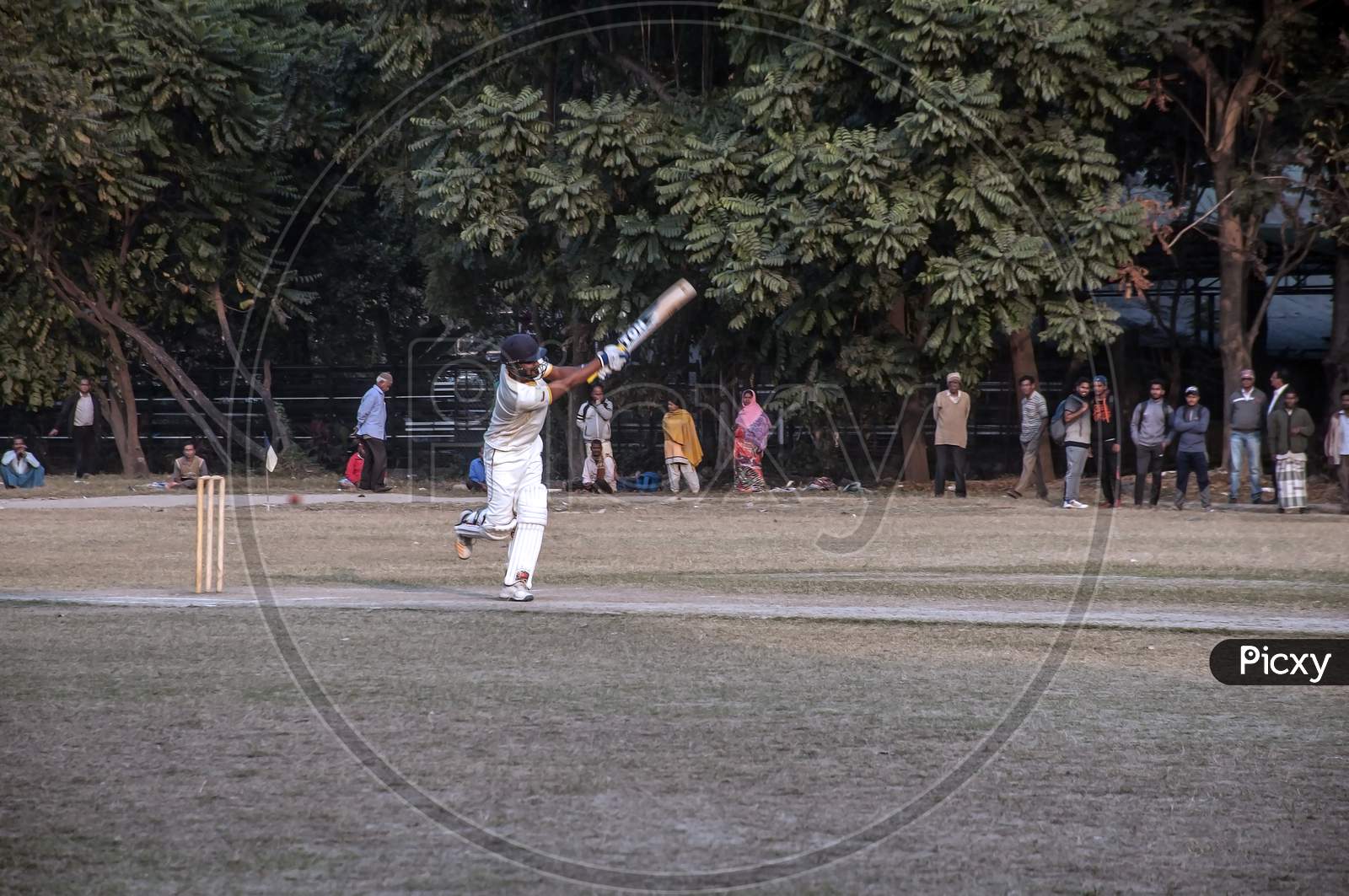 The batsman in action in a cricket ground.