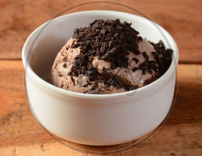 Choco Chips Ice Cream Scoop Served In A Bowl Over A Rustic Wooden Table, Selective Focus
