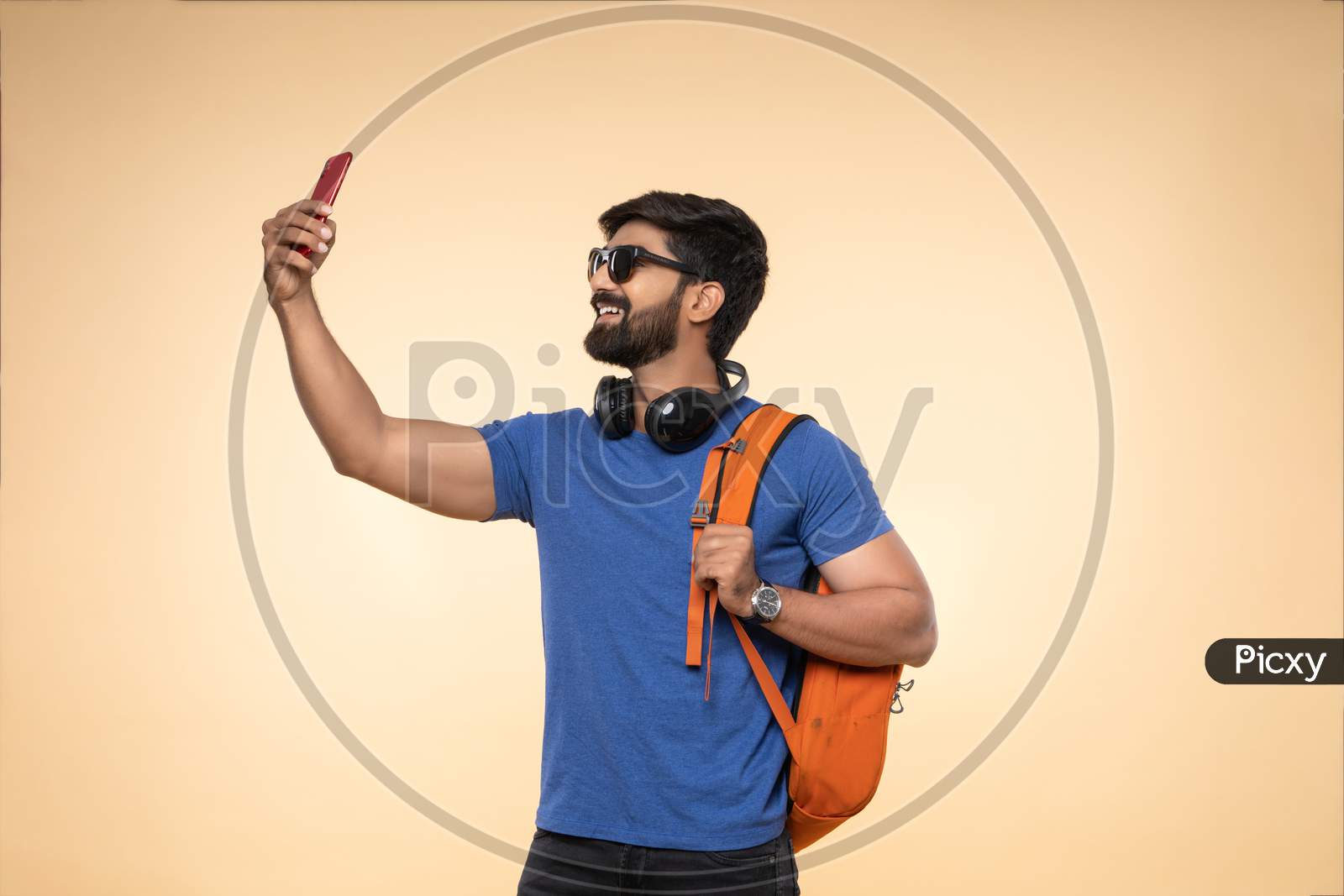 Indian young traveler taking selfie on his smartphone