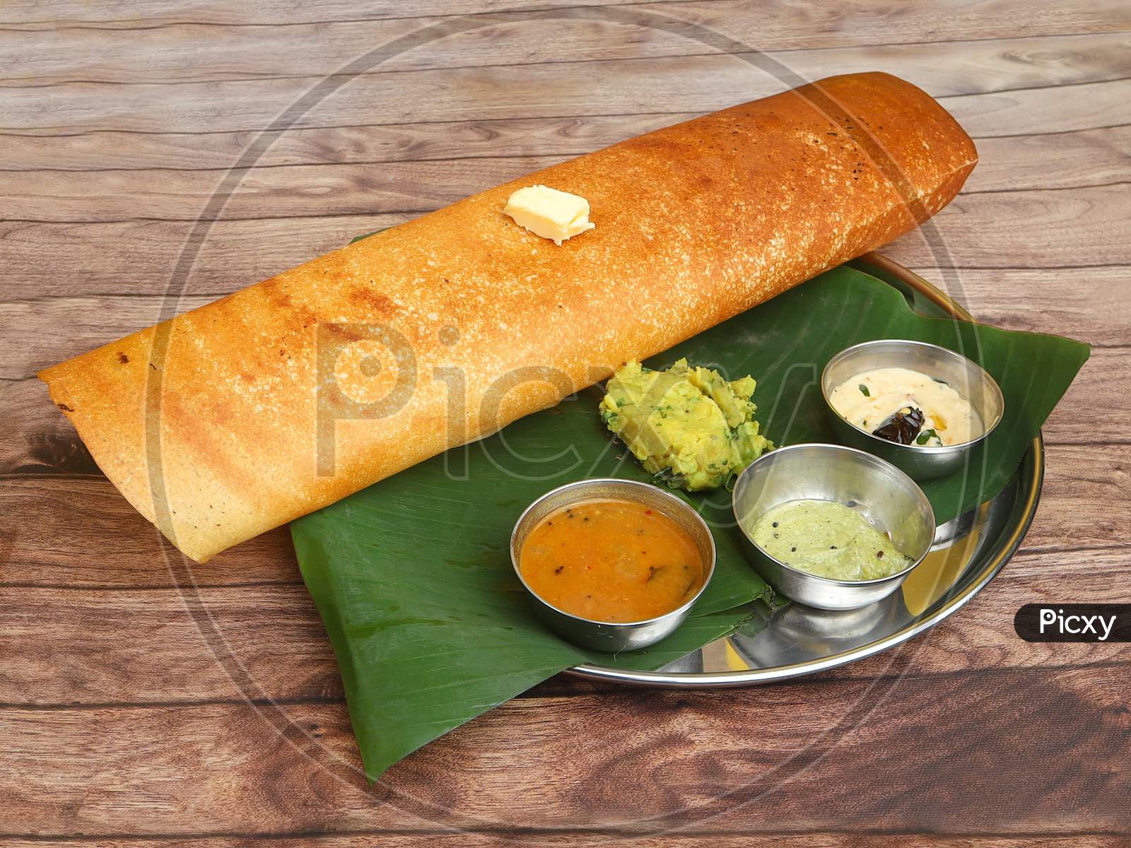 Butter Masala Dosa, A South Indian Traditional And Popular Crepe With Filling Of A Mixture Of Mashed Potatoes And Fried Onions, With A Butter Topping Served With Chutney And Sambar, Selective Focus