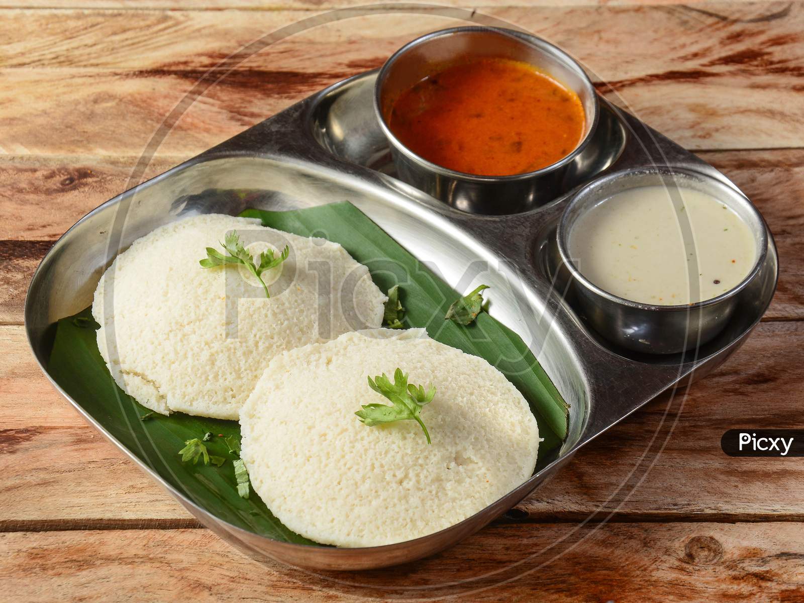 Idli Or Idly Is A Healthy Indian, Vegetarian, Traditional And Popular Steam Cooked Rice Cakes Served With Bowls Of Chutney And Sambar As Side Dishes.Selective Focus