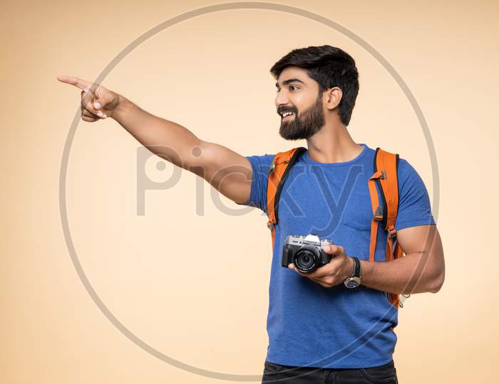 Indian young male tourist with a gesturing camera