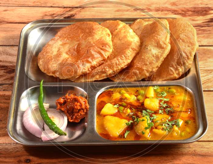 Puri Sabji - Indian Semi Dry Potato Spicy Recipe Also Known As Batata Or Aloo Ki Sabji, Served With Fried Poori.Selective Focus