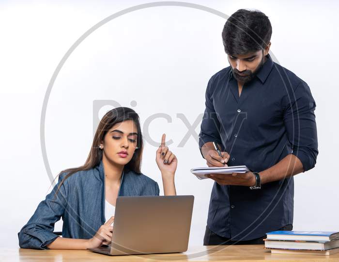 Indian female boss discussing office work with male employ